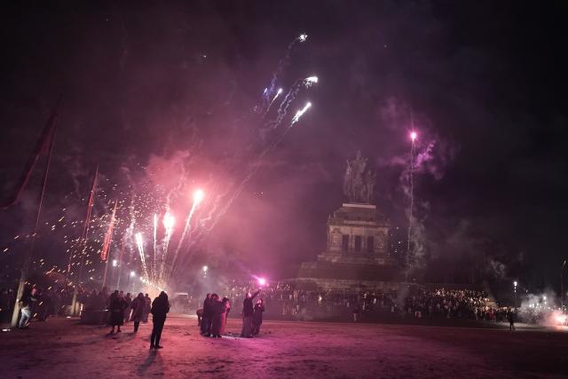 01 January 2026, Rhineland-Palatinate, Koblenz: Visitors fire off New Year's Eve fireworks at the equestrian statue of Kaiser Wilhelm at the confluence of the Rhine and Moselle rivers at the Deutsches Eck. Photo: Thomas Frey/dpa
