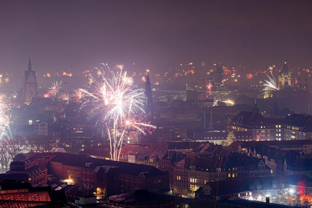01 January 2026, Lower Saxony, Hanover: Fireworks illuminate the sky over the Marktkirche (L) and the New Town Hall during the New Year celebrations. Photo: Moritz Frankenberg/dpa