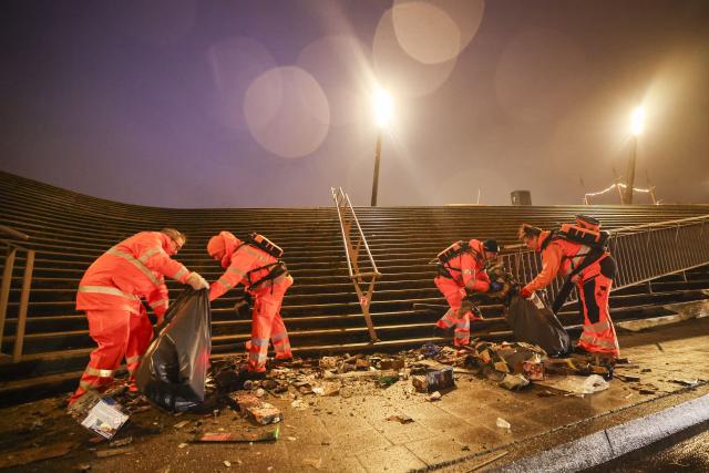 01 January 2026, Hamburg: Employees of the Hamburg city cleaning service clear burnt fireworks and other garbage from the Jan Fedder promenade in front of the Cap San Diego museum ship at the jetties in the port after New Year's Eve. Photo: Christian Charisius/dpa