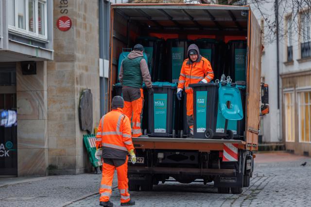 01 January 2026, Lower Saxony, Osnabrueck: Garbage cans are loaded in front of Osnabrück town hall during the traditional New Year's clean-up. The Ahmadiyya community's campaign will bring together 10,000 Muslims in more than 240 cities across Germany to clear the streets of New Year's garbage after praying together. Photo: Friso Gentsch/dpa
