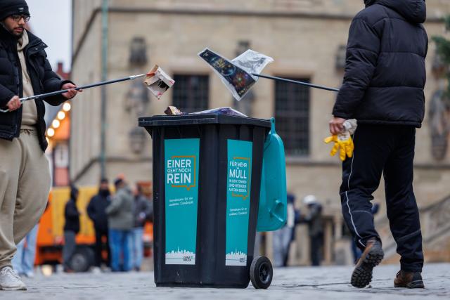 01 January 2026, Lower Saxony, Osnabrueck: Muslims collect garbage in garbage cans in front of Osnabrück town hall during the traditional New Year's clean-up. The Ahmadiyya community's campaign will bring together 10,000 Muslims in more than 240 cities across Germany to clear the streets of New Year's garbage after praying together. Photo: Friso Gentsch/dpa