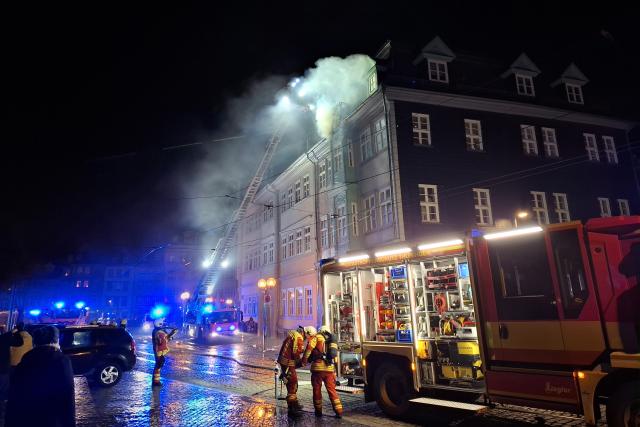 01 January 2026, Thuringia, Erfurt: The fire department fights a fire in the roof truss of a historic building on Domplatz in Erfurt on New Year's Eve. Photo: Marie Frech/dpa