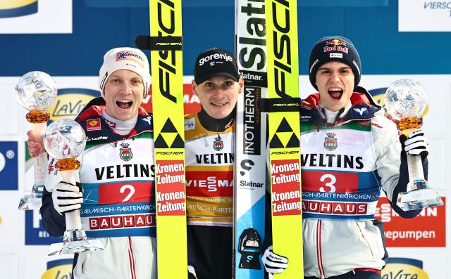 01 January 2026, Bavaria, Garmisch-Partenkirchen: Winner Slovenia's Domen Prevc  (C) celebrates on the podium with second-placed Austria's Jan Hoerl (L) and third-placed Austria's Stephan Embacher after the Men's large hill 2nd round of the Four Hills Tournament in the World Cup. Photo: Daniel Karmann/dpa