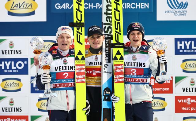 01 January 2026, Bavaria, Garmisch-Partenkirchen: Winner Slovenia's Domen Prevc  (C) celebrates on the podium with second-placed Austria's Jan Hoerl (L) and third-placed Austria's Stephan Embacher after the Men's large hill 2nd round of the Four Hills Tournament in the World Cup. Photo: Daniel Karmann/dpa