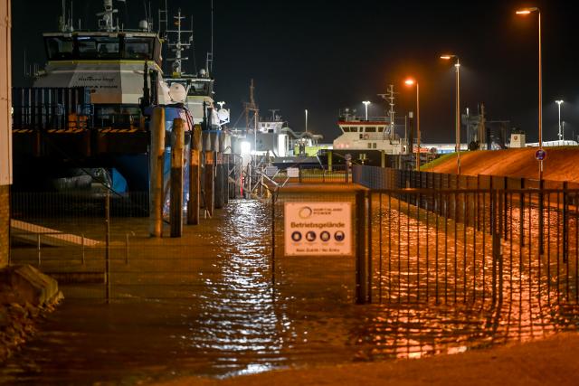 01 January 2026, Lower Saxony, Norddeich: Water overflows the quay wall at the port of Norddeich as water levels are expected to reach around 1.5 metres above mean high water. Photo: Lars Penning/dpa