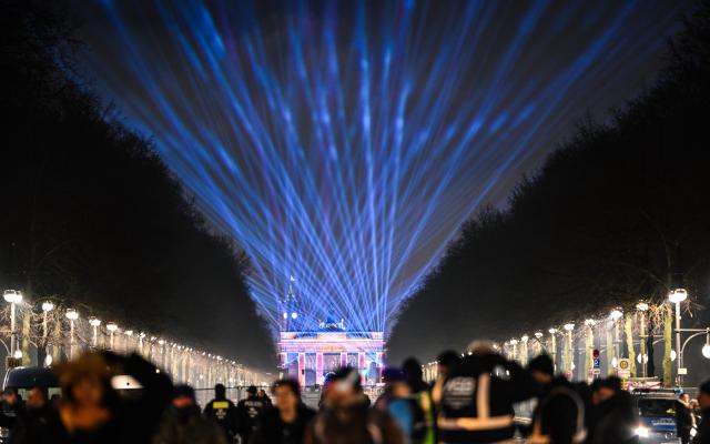 FILED - 31 December 2025, Berlin: Lasers light up the sky above 17 June Street towards the Brandenburg Gate during the "WeAreBerlin" party. Photo: Britta Pedersen/dpa