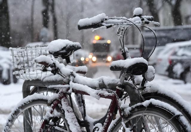 02 January 2026, Hamburg: Snow-covered bicycles are parked along a street in the Eimsbuettel district. Photo: Marcus Brandt/dpa