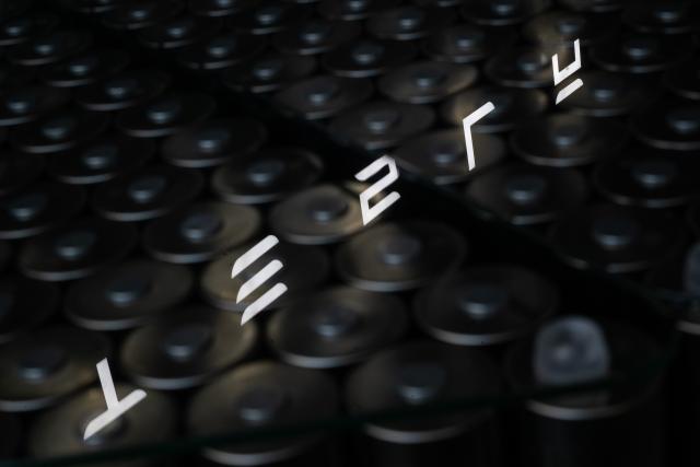 FILED - 16 December 2025, Brandenburg, Grünheide: The Tesla logo is reflected in a table of battery cells at the Tesla Gigafactory Berlin-Brandenburg. Photo: Sebastian Gollnow/dpa