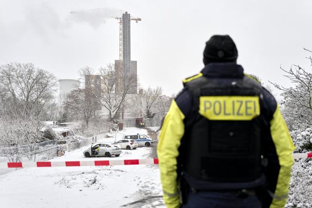 03 January 2026, Berlin: A police officer stands at the scene of the fire on the Teltow Canal. After a cable bridge caught fire, 50,000 households and 2,000 businesses in south-west Berlin lost power. Photo: Michael Ukas/dpa
