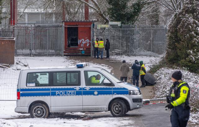 03 January 2026, Berlin: Police officers stand at the site of a cable bridge fire in front of the Lichterfelde power station on the Teltow Canal. After a cable bridge caught fire, 50,000 households and 2,000 businesses in south-west Berlin lost power. Photo: Michael Kappeler/dpa