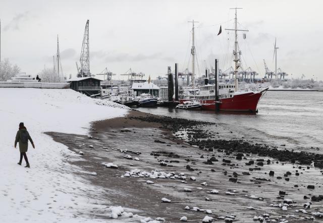 03 January 2026, Hamburg: Passers-by are out and about on the snow-covered Elbe beach in Oevelgönne. Photo: Christian Charisius/dpa