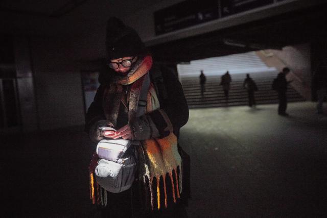 03 January 2026, Berlin: Bonnie from Berlin walks through Wannsee station with a cell phone light after a power outage in Berlin.  After a cable bridge caught fire, 50,000 households and 2,000 businesses in south-west Berlin lost power. Photo: Michael Kappeler/dpa