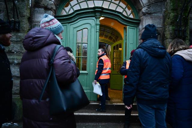 03 January 2026, Berlin: An S-Bahn employee (C) explains to passers-by during a power cut at Mexikoplatz S-Bahn station in south-west Berlin that no more trains are stopping at the station because the platform is not lit. After a cable bridge caught fire, 50,000 households and 2,000 businesses in south-west Berlin lost power. Photo: Sebastian Christoph Gollnow/dpa