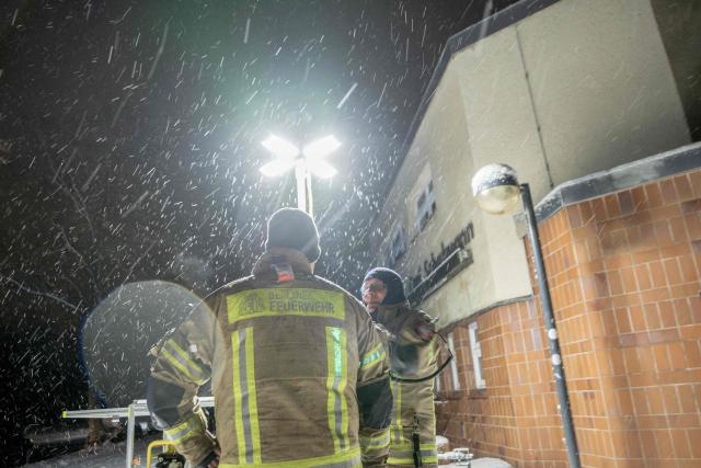 03 January 2026, Berlin: Emergency services from the Berlin fire department stand in front of a generator light pole at a civil protection contract point in front of the Carl Schuhmann sports facility in the Lichterfelde district during a power outage. After a cable bridge caught fire, 50,000 households and 2,000 businesses in south-west Berlin lost power. Photo: Carsten Koall/dpa