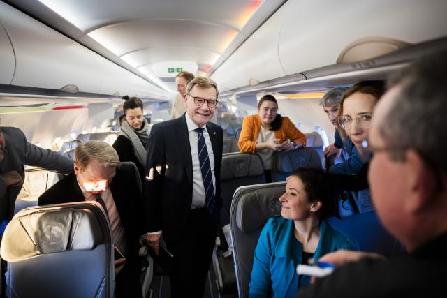 05 January 2026, Brandenburg, Schönefeld: Johann Wadephul (C), Foreign Minister, welcomes media representatives on the flight to Vilnius in the A321LR of the German Air Force. Photo: Christoph Soeder/dpa