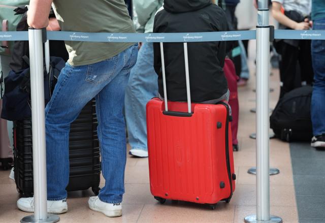 FILED - 18 October 2024, Hamburg: Passengers queue at the check-in counters in the departure hall at Hamburg Airport. Photo: Marcus Brandt/dpa