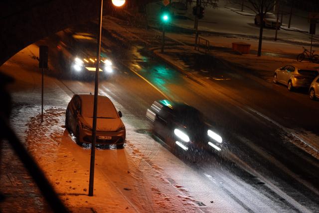 06 January 2026, Bavaria, Wuerzburg: Cars navigate a road partially covered with snow in the early morning. Photo: Karl-Josef Hildenbrand/dpa