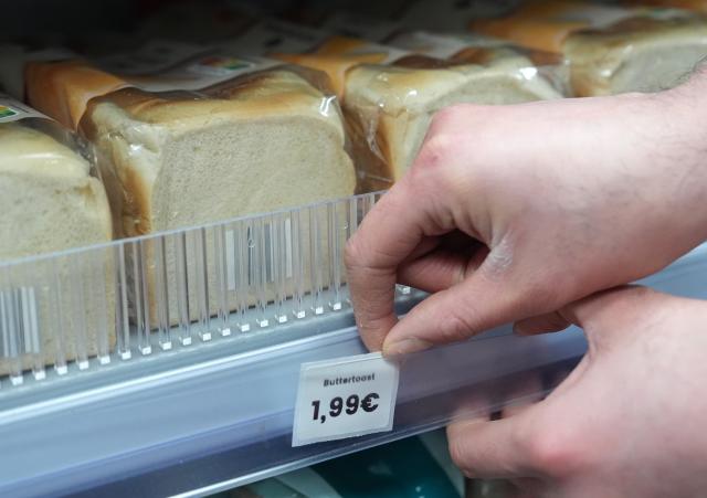 FILED - 05 January 2026, Hamburg: A kiosk employee puts a price tag for buttered toast on a shelf. German consumer prices rose by 2.2% year-on-year in 2025, with inflation remaining on the same level recorded in 2024, official estimates showed on Tuesday. Photo: Marcus Brandt/dpa