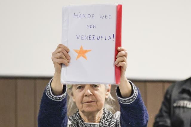 06 January 2026, Lower Saxony, Verden: The defendant Daniela Klette holds up a note reading "Hands off Venezuela!" in the provisional courtroom of the Verden district court as her trial continues. Klette is accused of attempted murder and several robberies, which she is alleged to have committed together with accomplices. Photo: Focke Strangmann/dpa