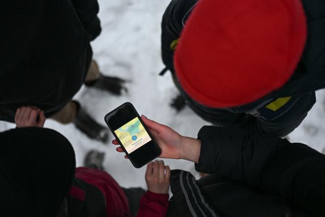 08 January 2026, Lower Saxony;East Frisia, Leer: Four students look at a smartphone displaying the school closure for the Leer district. Photo: Lars Penning/dpa