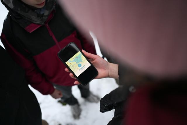 08 January 2026, Lower Saxony;East Frisia, Leer: Four students look at a smartphone displaying the school closure for the Leer district. Photo: Lars Penning/dpa