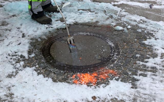 08 January 2026, Mecklenburg-Western Pomerania, Rerik: A workers uses a gas burner to uncover a frozen manhole cover in the harbor on the Salzhaff. Ice and snow have northern Germany firmly in their grip. Photo: Bernd Wüstneck/dpa