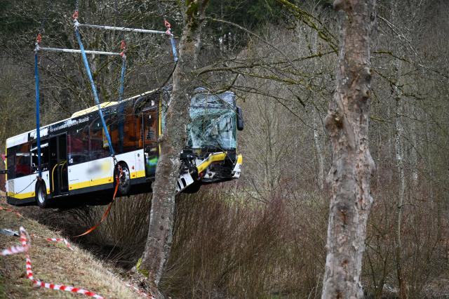 09 January 2026, Baden-Württemberg, Ebhausen: A crane lifts a bus that has slid down a slope near Ebhausen in the Calw district. A bus left the road near Ebhausen in Baden-Württemberg on a slippery road and slid around five meters down a slope. Photo: Katharina Kausche/dpa - ATTENTION: License plate and logos on the bus have been pixelated for legal reasons