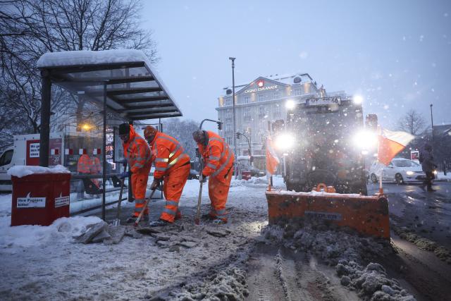 09 January 2026, Hamburg: Employees of Stadtreinigung Hamburg clear ice and snow from a bus stop at Stephansplatz during a media event. Photo: Christian Charisius/dpa