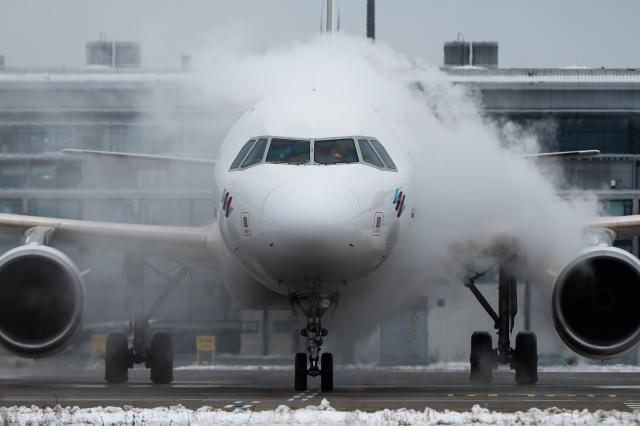 09 January 2026, Brandenburg, Schönefeld: A Eurowings aircraft is being de-iced on a de-icing area at Berlin-Brandenburg BER Airport. Photo: Christophe Gateau/dpa