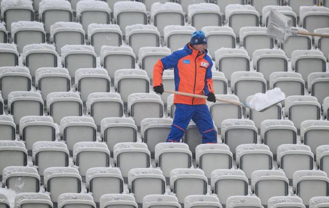 09 January 2026, Thuringia, Oberhof: A helper shovels snow onto the stands in the biathlon stadium during the IBU Biathlon World Cup in Oberhof. Photo: Hendrik Schmidt/dpa