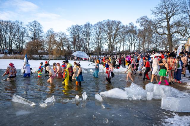 10 January 2026, Berlin: Bathers wade into the cold water between ice floes at Lake Orankesee during the 40th winter swim organized by the Berliner Seehunde association. Photo: Christophe Gateau/dpa