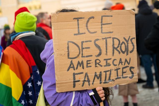 11 January 2026, Berlin: A participant holds a poster reading "Ice destroys American families" near the US embassy in Berlin, during a vigil for Renee Nicole Good, who was killed during an operation by the US immigration authorities (ICE). Photo: Christophe Gateau/dpa