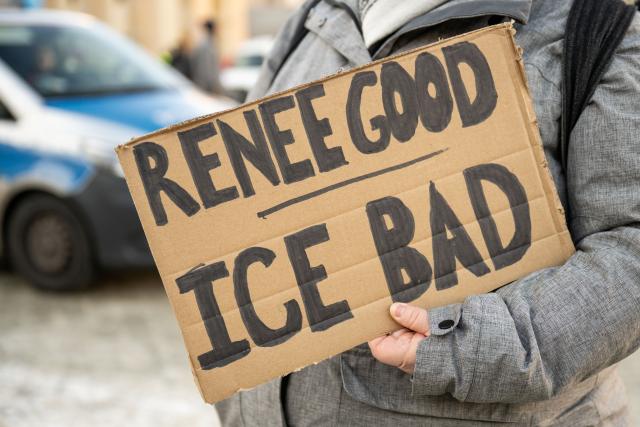 11 January 2026, Berlin: A participant holds a poster reading "Renee Good - Ice Bad" near the US embassy in Berlin, during a vigil for Renee Nicole Good, who was killed during an operation by the US immigration authorities (ICE). Photo: Christophe Gateau/dpa