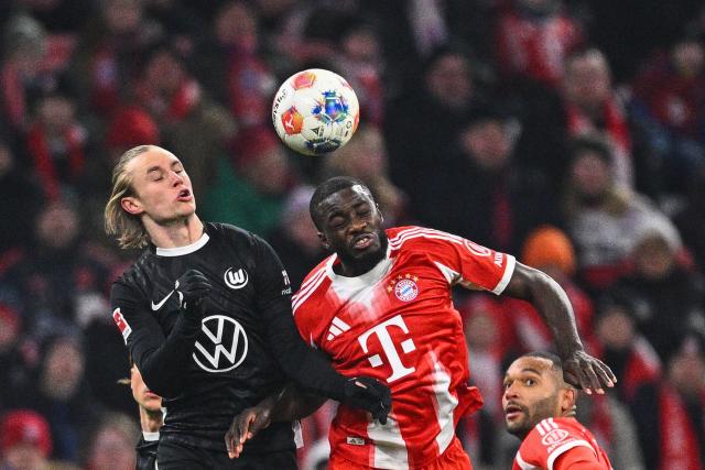 11 January 2026, Bavaria, Munich: VfL Wolfsburg's Patrick Wimmer (L) and  Bayern Munich's Dayot Upamecano battle for the ball during the German Bundesliga soccer match between Bayern Munich and VfL Wolfsburg at Allianz Arena. Photo: Tom Weller/dpa - IMPORTANT NOTICE: DFL and DFB regulations prohibit any use of photographs as image sequences and/or quasi-video.