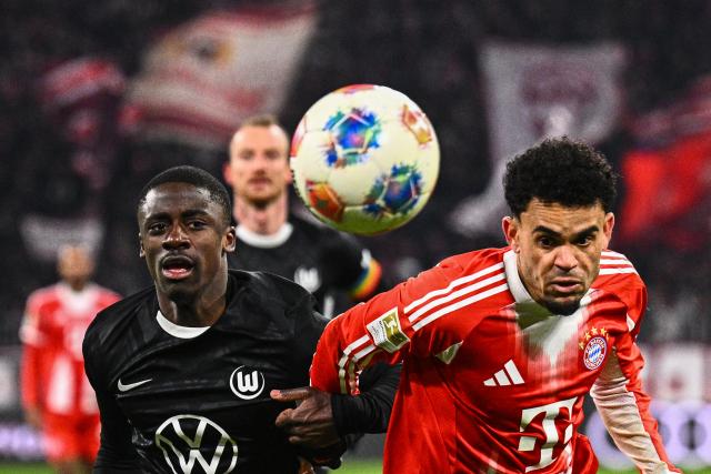 11 January 2026, Bavaria, Munich: Bayern Munich's Luis Diaz and VfL Wolfsburg's Sael Kumbedi battle for the ball during the German Bundesliga soccer match between Bayern Munich and VfL Wolfsburg at Allianz Arena. Photo: Tom Weller/dpa - IMPORTANT NOTICE: DFL and DFB regulations prohibit any use of photographs as image sequences and/or quasi-video.