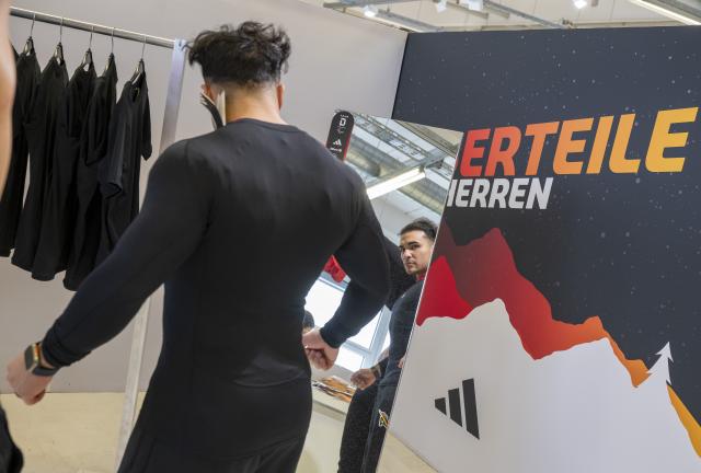 12 January 2026, Bavaria, Munich: German bobsledder Issam Ammour stands in front of a mirror while getting dressed for the Olympic Winter Games Milano Cortina 2026. Photo: Peter Kneffel/dpa