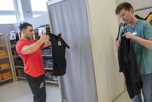 12 January 2026, Bavaria, Munich: German bobsledder Issam Ammour (L) tries on a top during the clothing fitting for the Olympic Winter Games Milano Cortina 2026. Photo: Peter Kneffel/dpa