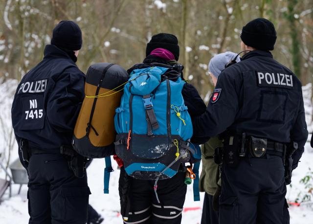 12 January 2026, Lower Saxony, Lueneburg: German Police officers accompany an activist, after a small group of people demonstrated against the expansion of the A39 motorway in a wooded area near Lueneburg. Photo: Philipp Schulze/dpa