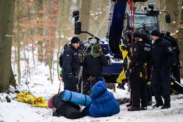12 January 2026, Lower Saxony, Lueneburg: German Police officers accompany an activist, after a small group of people demonstrated against the expansion of the A39 motorway in a wooded area near Lueneburg. Photo: Philipp Schulze/dpa