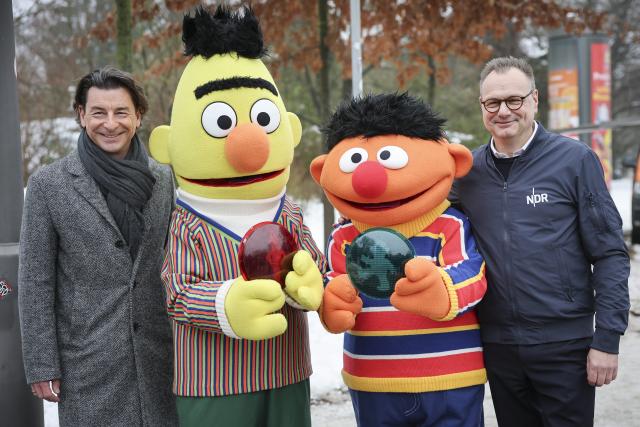 13 January 2026, Hamburg: Director General of Norddeutscher Rundfunk (NDR) Hendrik Luenenborg (R) and Managing Director of Sesame Workshop Europe Bernhard Gloeggler (L) pose for a picture with life-size figures of Ernie and Bert from Sesame Street at the inauguration of a pedestrian traffic light featuring Sesame Street characters. The two popular Sesame Street characters will be seen as traffic light figures at the pedestrian crossings at the corner of Hugh-Greene-Weg and Julius-Vosseler-Strasse, as well as at the corner of Rothenbaumchaussee and Oberstrasse in Hamburg. Photo: Christian Charisius/dpa