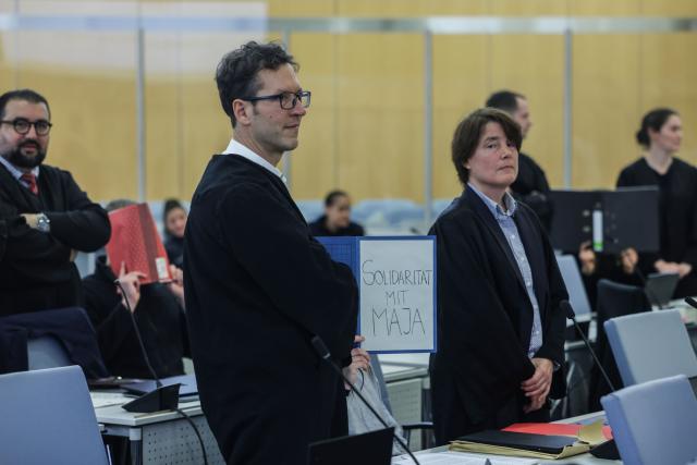 13 January 2026, North Rhine-Westphalia, Duesseldorf: One defendant (C) sits with a file folder in front of her face, with the inscription "Solidarity with Maja" in the courtroom of the Higher Regional Court in Duesseldorf. Six suspected left-wing extremists are on trial before the Higher Regional Court, for allegedly having chased and beaten neo-Nazis and right-wing extremists in Budapest. Photo: Oliver Berg/dpa
