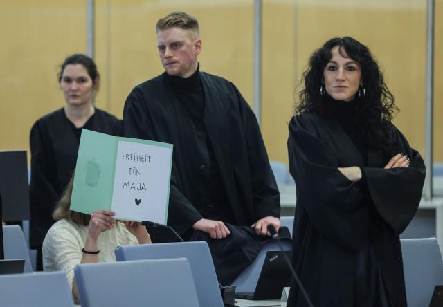 13 January 2026, North Rhine-Westphalia, Duesseldorf: One defendant sits with a file folder in front of her face, with the inscription "Solidarity with Maja" in the courtroom of the Higher Regional Court in Duesseldorf. Six suspected left-wing extremists are on trial before the Higher Regional Court, for allegedly having chased and beaten neo-Nazis and right-wing extremists in Budapest. Photo: Oliver Berg/dpa