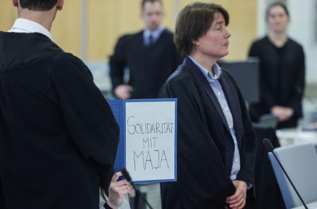 13 January 2026, North Rhine-Westphalia, Duesseldorf: A defendant sits with a file folder in front of her face, with the inscription "Solidarity with Maja" in the courtroom of the Higher Regional Court in Duesseldorf. Six suspected left-wing extremists are on trial before the Higher Regional Court, for allegedly having chased and beaten neo-Nazis and right-wing extremists in Budapest. Photo: Oliver Berg/dpa