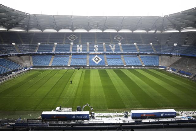 FILED - 12 January 2026, Hamburg: Workers clear snow from the sidelines and seats in the stands at Volksparkstadion. German Bundesliga match between SV Hamburg and Bayer Leverkusen has been postponed less than three hours before the kick-off for security reasons after "extreme thaw" set in earlier in the day. Photo: Christian Charisius/dpa