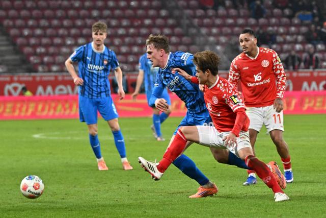 13 January 2026, Rhineland-Palatinate, Mainz: Mainz' Kaishu Sano (2nd L) and Heidenheim's Mikkel Kaufmann battle for the ball during the German Bundesliga soccer match between FSV Mainz 05 and  1. FC Heidenheim at Mewa Arena. Photo: Torsten Silz/dpa - IMPORTANT NOTICE: DFL and DFB regulations prohibit any use of photographs as image sequences and/or quasi-video.