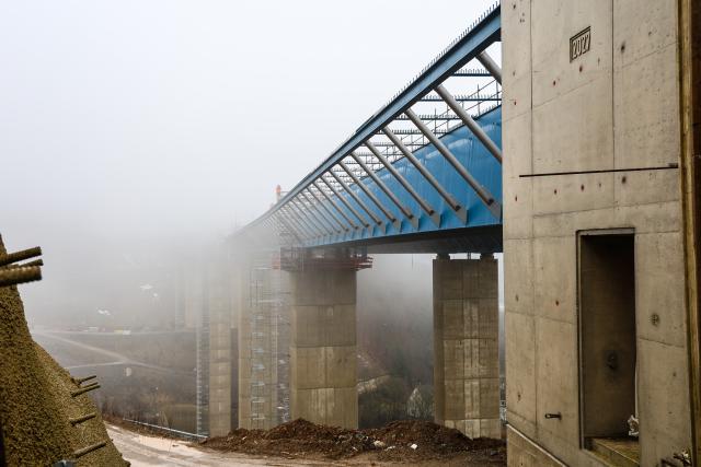 14 January 2026, North Rhine-Westphalia, Lüdenscheid: View of the construction site. Another step forward in the construction work on the Rahmede valley bridge: The first bridge over the Rahmede Valley on the A45 was completed shortly before Christmas. Traffic is currently being routed over it in narrow lanes. A second bridge structure is being built in parallel to accommodate traffic in the opposite direction in future. During the so-called "steel wedding", the two halves of the bridge, which are being pushed over the pillars in sections from both sides of the valley, are joined and welded together. Photo: Alex Talash/dpa