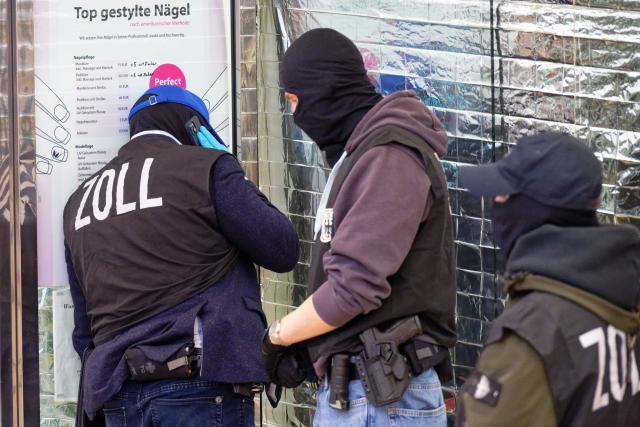 14 January 2026, North Rhine-Westphalia, Cologne: Customs officers stand in front of a nail salon in the Neumarktgalerie in the city center. In the fight against the smuggling of workers into Germany and illegal employment in nail salons, over 1,000 officers in several federal states have executed arrest warrants and searched premises. Photo: Henning Kaiser/dpa