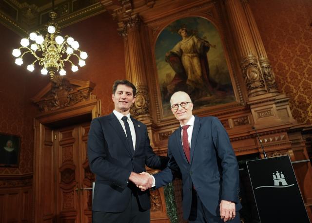 14 January 2026, Hamburg: First Mayor of Hamburg Peter Tschentscher (R) and Deputy Mayor of Paris for Sports Pierre Rabadan shake hands after a press conference in the Phoenix Hall at City Hall. The focus of the discussion between Tschentscher and Rabadan is an exchange of experiences regarding the possible hosting of the Olympic and Paralympic Games in Hamburg. Photo: Marcus Brandt/dpa
