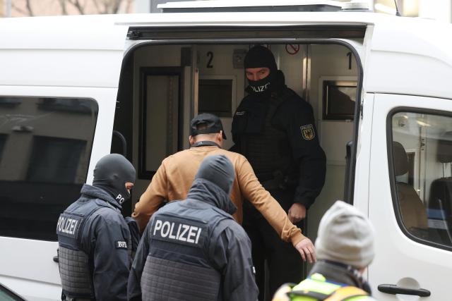 14 January 2026, North Rhine-Westphalia, Duesseldorf: Federal police officers escort a person into a prison transport vehicle. In the fight against the smuggling of workers into Germany and illegal employment in nail salons, more than 1,000 officers from the federal police, customs, tax investigation, and public prosecutor's office executed arrest warrants and searched premises in several federal states on Wednesday. Photo: David Young/dpa