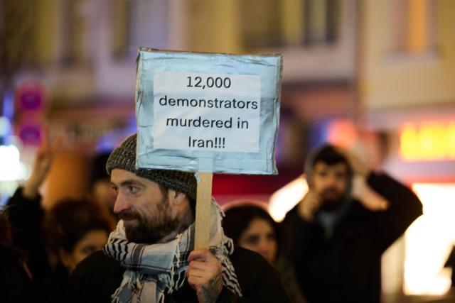 14 January 2026, Berlin: A man holds a placard during a demonstration under the slogan "Protest against the death machine of the Islamic Republic of Iran," organized by the Woman Life Freedom Collective. Photo: Annette Riedl/dpa